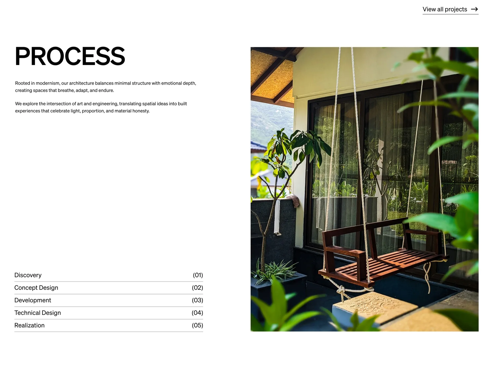 Wooden swing hanging on a porch surrounded by green plants and reflecting in large glass windows.